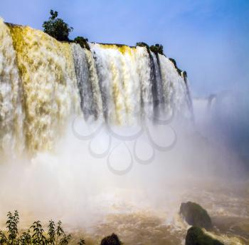Iguazu Falls in South America, on the border of two countries: Brazil and Argentina. Concept of active and extreme tourism. The World of raging water