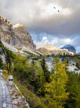 The road on the pass Faltsarego. Concept of extreme and active tourism. Rocks in the Dolomites covered the sunset rays
