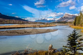 The sunny autumn in the Rockies of Canada. Delightful reservoir Abraham lake. Concept of ecological and active tourism