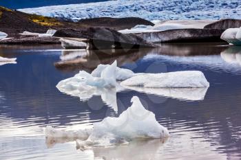 Summer in Iceland. The concept of extreme northern tourism. The cold lake with splinters of ice floes formed by thawed snow of glacier Vatnajokull