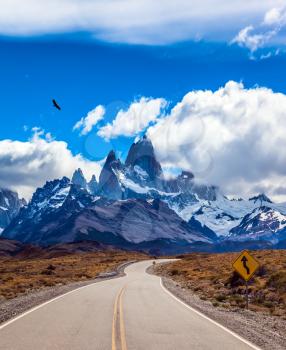 Highway to the majestic Mount Fitz Roy. Argentine Patagonia. Summer day in February. The concept of active and extreme tourism. The Andean condors hover over the prairie