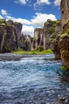 Canyon Icelandic fairy tales and legends - Fyadrarglyufur. Steep cliffs, overgrown with green moss, surrounded by a very fast river with cold water