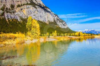 Rocky Mountains are reflected in the smooth water of Lake Abraham. Indian Summer in the Rockies of Canada. Concept of ecological and active tourism