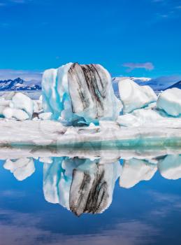  Ice lagoon in July.  Ice floes and icebergs are reflected in the mirrored water of ocean. Summer in Iceland