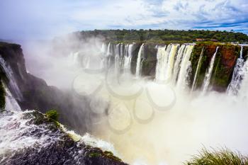 Grandiose waterfalls Iguazu in the rainy season. The most full-flowing waterfall in the world on the Parana River. The Devil's throat /Garganta del Diablo/. Concept of active and extreme tourism