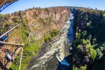 The famous Victoria Falls in Zambia. Bungee jumping from a bridge near waterfall