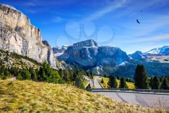 The concept of extreme and ecological tourism. Impressive ridge of dolomite rocks. Picturesque road through the Sella Pass, Dolomites. Indian summer in the Tirol