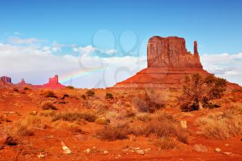 Magical landscape Monument Valley in Arizona. Famous rock - mitts of red sandstone. In the sky a rainbow
