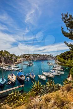 Graceful sailing yachts in the sea fjord.  National park of Calanques in Provence, between Marseille and Kassis. The picturesque gulf with turquoise water at coast of the Mediterranean Sea