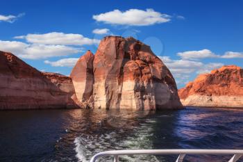  Walk on the tourist boat. Foam boat trail crosses the emerald waters. Red sandstone hills surround the lake. Lake Powell on the Colorado River
