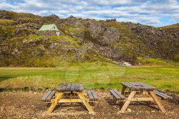 Summer trip to Iceland. The green lawn in the Valley National Park Landmannalaugar. Wooden picnic tables