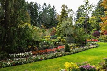 Butchart Gardens - amazingly beautiful gardens on Vancouver Island, Canada. Sunken Garden - the most beautiful part of the park complex. Flower beds of colorful flowers and walking paths for tourists