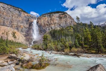 Autumn waterfall forms a full-flowing water flow of pearl color. Rocky Mountains of Canada. Yoho National Park