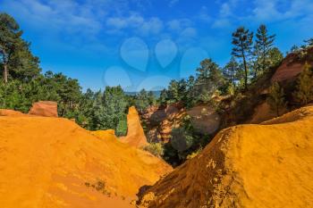  Multi-colored ocher outcrops - from yellow to orange-red. Roussillon, Provence Red Village. The picturesque canyon of ocher - natural dyes