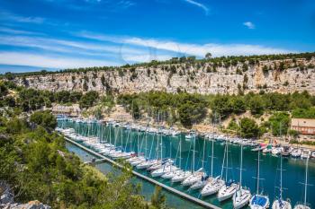 White sailboats moored in rows near the shore. Picturesque small bay - Calanques between Marseille and Cassis