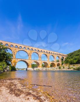 Three-tiered aqueduct Pont du Gard - the highest in Europe. The bridge was built in Roman times on the river Gardon. Provence, spring sunny day