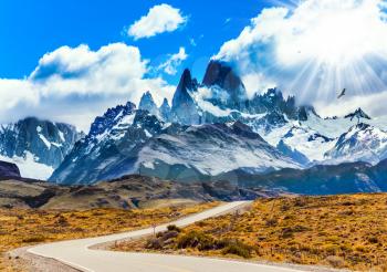 Fine highway to the majestic Mount Fitz Roy. Argentine Patagonia. Summer day in February. The concept of active and extreme tourism. The summer sun illuminates the prairie