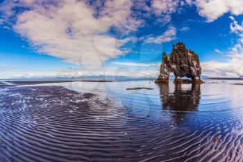 Stone mammoth Iceland. The picturesque cliff in Bay of Huna during low tide at sunset