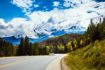 The grandiose nature of the Rockies of Canada. The Highway 93 Icefields Parkway passes among the snow-capped mountains and autumn multicolored forests. The concept of active car tourism
