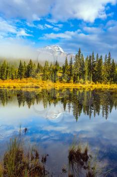 Patricia Lake reflects the snowy peak of the Pyramid Mountain. Indian summer. The concept of extreme and ecotourism