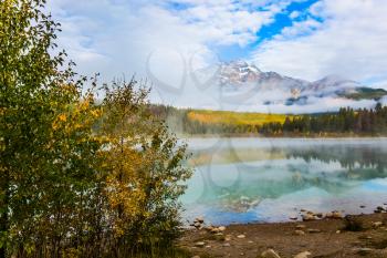 Patricia Lake in the Rocky Mountains. The water reflects the peak of the Pyramid Mountain. Indian Summer in Canada. The concept of ecotourism 
