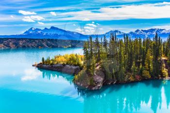  Warm sunny day in Indian summer. Abraham Lake in the Rockies of Canada. Turquoise smooth water reflects the sky. The concept of ecological and active tourism