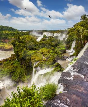Picturesque basaltic ledges form the famous waterfalls. Waterfalls Iguazu on the border of Argentina, Brazil and Paraguay. The concept of active and exotic tourism