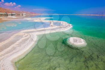 The evaporated salt has developed into fantastic patterns. The concept of medical and ecological tourism. Reduced water in the very salty Dead Sea, Israel