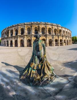  The monument to toreador is placed into square. The Roman amphitheater in Nymes, Provence. The picture is made a lens  Fisheye