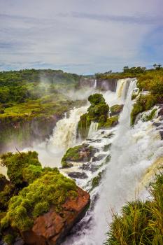  Picturesque basaltic rocks form the famous waterfalls. World of falling water. The waterfalls Iguazu. The concept of active and exotic tourism