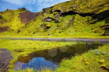  Picturesque basalt hills overgrown green grass and moss. On bottom of canyon many streams flow. Canyon Pakgil in Iceland