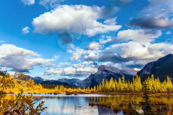 The lake Vermilion. Warm sunny autumn day. Lush cumulus clouds are reflected in the smooth water of the lake. The concept of ecological, photographic and active tourism