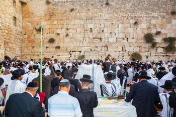 JERUSALEM, ISRAEL - OCTOBER 12, 2014:  The area in front of Western Wall of Temple filled with people. The Jews of ritual clothes - tallit hold four ritual plants. Sukkot, Blessing of the Kohanim