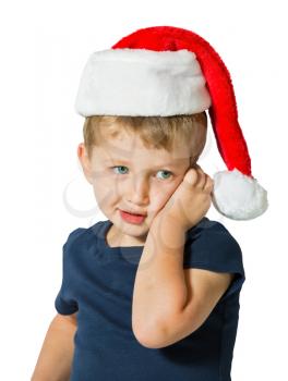 The child merry blue eyes and blond soft hair. Cute three year old boy in a red cap of Santa Claus. Photo executed on a white background