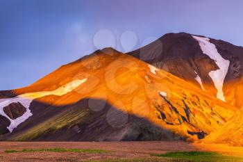  Sunrise National Park Landmannalaugar, Iceland. Fairy dawn. Valleys, mountains and glaciers covered with warm orange light