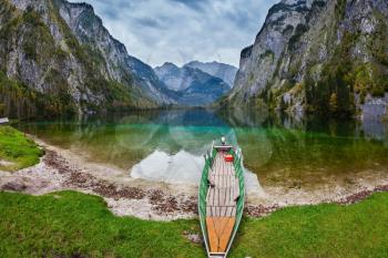  The magic blue lake Obersee in Bavarian Alps. Fishing boat with a small engine in shallows of the lake. Concept of active tourism and ecological tourism