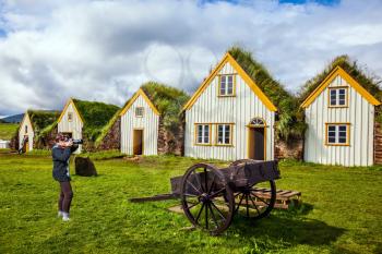 Ethnographic Museum-estate Glaumbaer, Iceland. The woman photographed the old village. The concept of the historical and cultural tourism