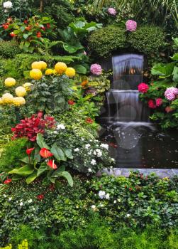 Gorgeous three-stage fountain Mirror stream among the flowers. Butchart Garden Park on Vancouver Island, Canada