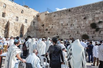 JERUSALEM, ISRAEL - OCTOBER 12, 2014:  Morning autumn Sukkot. Hhuge crowd of faithful Jews wearing white prayer shawls and black long-skirted coats