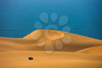  Dangerous and gorgeous jeep - safari through the huge sand dunes on the ocean shore. Atlantic coast of Namibia, south of Africa. The concept of exotic and extreme tours