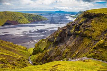 Canyon Pakgil in Iceland. Basalt hills covered with green grass. Streams from melting glaciers flowing down the canyon