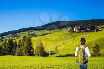  Active elderly woman-tourist with backpack admiring the beauty of the Dolomites. Northern Italy, Tirol. The concept of an active and eco-tourism