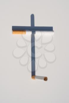 Royalty Free Photo of Cigarettes Casting a Cross Shadow