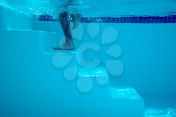 Royalty Free Photo of a Foot Going Up Swimming Pool Steps