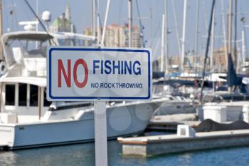 Royalty Free Photo of a No Fishing and No Rock Throwing Sign at a Marina