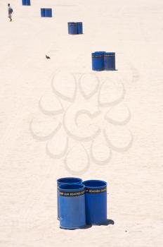 Royalty Free Photo of Garbage Bins on a Beach