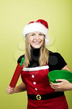 Woman in Christmas apron holding baking utensils