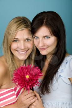 Royalty Free Photo of Two Women Holding a Pink Flower