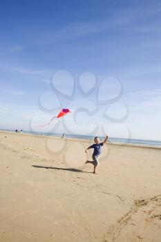 Royalty Free Clipart Image of a Young Child Running on the Beach