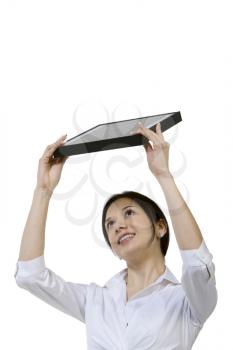 Royalty Free Photo of a Woman Holding a Laptop Over Her Head